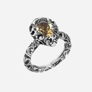 Anello in argento brunito inciso a mano con l’antica tecnica
del bulino, con una goccia naturale piccola e sfaccettata, gambo intarsiato