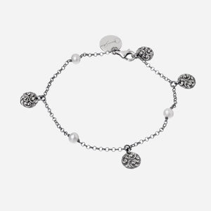 Bracciale in argento brunito inciso, quattro lenticchie piccole e tre perle.
Chiusura con moschettone