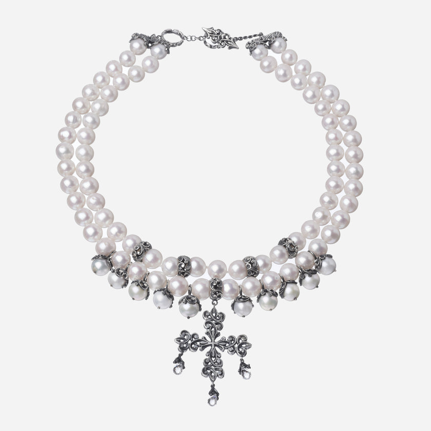 Collana composta da due file di perle, separatori e mezze sfere in argento lavorati a mano e incisi, croce finale intarsiata con gocce naturali. Chiusura a T barra